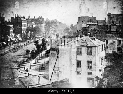 Il Boulevard du Temple di Louis Daguerre. Scattata nel 1839 con il suo processo brevettato Daguerrotype, si ritiene che questa sia la prima foto in assoluto a mostrare una persona che buccia. La bassa velocità dell'otturatore significa che tutto il traffico non si presenta, ma l'uomo che lucida le scarpe e il suo cliente sono visibili in primo piano. Daguerre è stato l'inventore del primo processo fotografico disponibile al pubblico. Il processo era disponibile nel 1839, ma è stato completamente sostituito in 20 anni. Il processo era complesso (e pericoloso, con vapori di mercurio) e dal 1856 erano disponibili metodi molto più economici e più semplici. Foto Stock