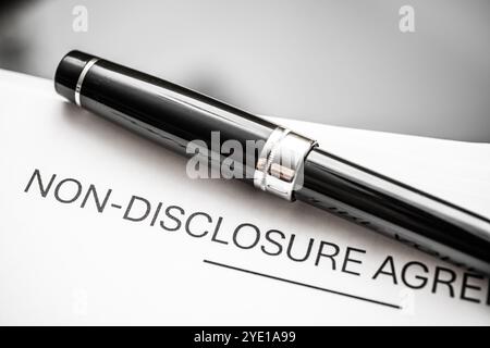 Una sofisticata penna nera si basa su un accordo di non divulgazione, che simboleggia la riservatezza aziendale, i contratti legali e la conformità aziendale. Perfec Foto Stock