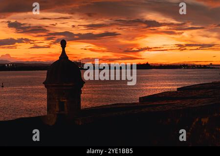 Sagoma Di Uno storico forte "Garita" contro Un vibrante tramonto sull'oceano nella Vecchia San Juan, Porto Rico. Foto Stock
