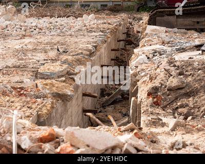 Demolizione di un edificio con solide fondamenta. Piastra di base in acciaio e cemento armato. Macerie dalla muratura che si trovano intorno. Foto Stock