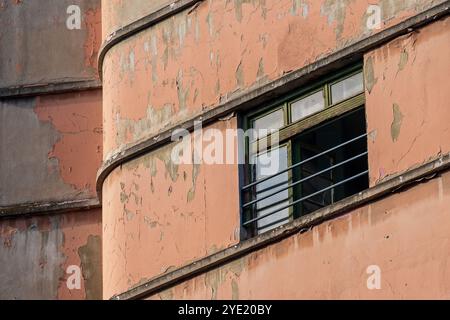 Eleganza sbiadita: Finestra aperta su un vecchio edificio rosso-arancione Foto Stock