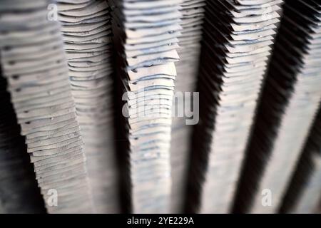 Struttura di chiusura della superficie dello scambiatore di calore con alette a piastra. Vecchio dispositivo di scambio termico piastre piegate con tracce di ruggine da corrosione. Focalizzazione selettiva industriale ba Foto Stock