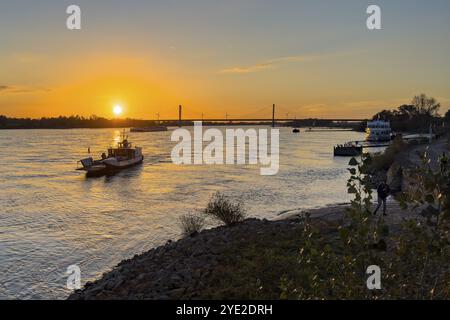Tramonto sul fiume Reno basso Reno, a sinistra in primo piano piccolo traghetto passeggeri a due ruote Rees, sullo sfondo ponte sul Reno due- Foto Stock