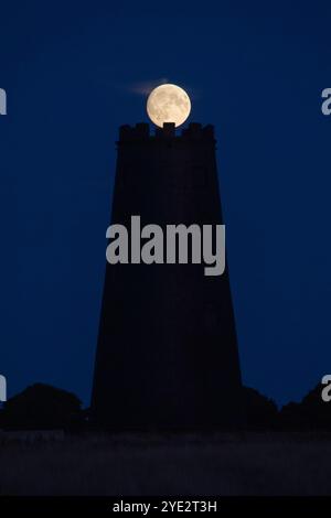 Una luna piena che si innalza sul Black Mill a Beverley Westwood a Beverley, nell'East Yorkshire Foto Stock