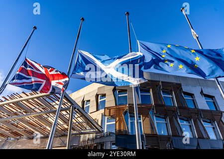 Città di Edimburgo, Regno Unito. 29 ottobre 2024 nella foto: La mattina del funerale dell'ex primo ministro Alex Salmond, il Parlamento scozzese sventola a mezz'asta la bandiera dell'Unione, la Saltire e la bandiera dell'Unione europea. Crediti: Rich Dyson/Alamy Live News Foto Stock