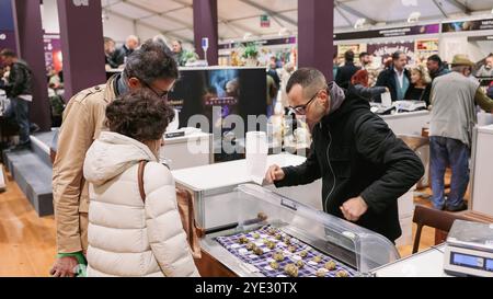 La folla si riunisce al Festival del Tartufo d'Alba in Italia, dove i partecipanti esaminano i vari tartufi esposti presso gli stand. Foto Stock