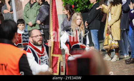 Un vivace festival ad Alba, in Italia, ospita partecipanti vestiti con costumi storici. La folla si riunisce per assistere a spettacoli elaborati, creando un atmo Foto Stock