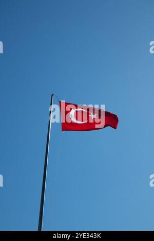 Bandiera turca contro un cielo azzurro. Una bandiera rossa con una stella bianca e una mezzaluna Foto Stock