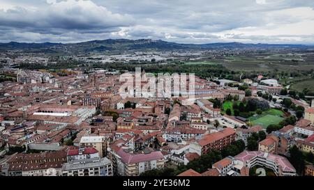 Una prospettiva aerea cattura la pittoresca cittadina di Alba in Italia, mettendo in evidenza i suoi edifici iconici e le lussureggianti colline verdi. L'atmosfera si riflette Foto Stock