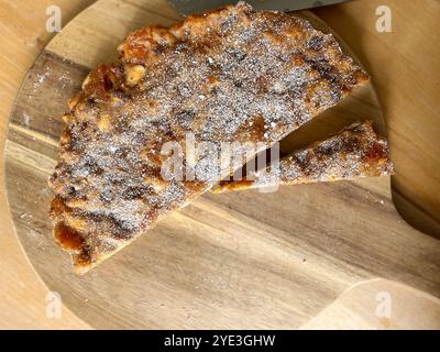 Fotografia del cibo da tavolo di un panforte da dessert italiano a fette su un tagliere di legno Foto Stock