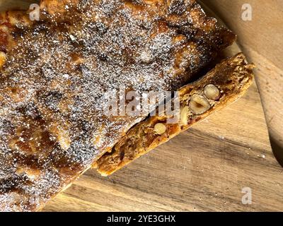 Fotografia ravvicinata di un panforte da dessert italiano a fette su un tagliere di legno Foto Stock