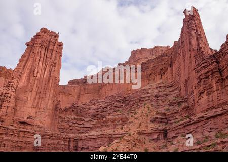 Vista spettacolare delle maestose Fisher Towers di Moab, Utah. Le formazioni di roccia rossa si innalzano contro un cielo parzialmente nuvoloso, mostrando la bellezza naturale Foto Stock