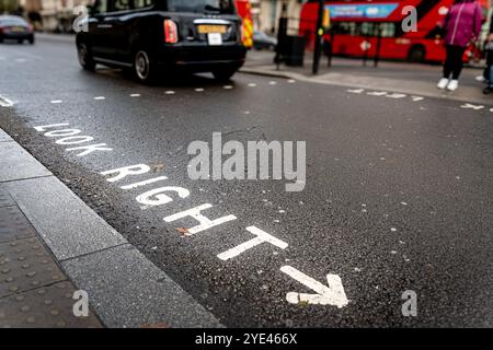 guarda a destra scritto sulla strada asfaltata nel regno unito come simbolo del traffico a sinistra Foto Stock