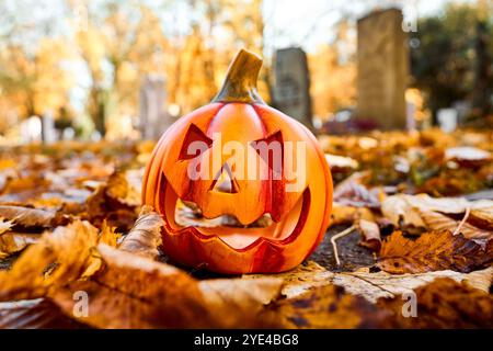 Baviera, Germania - 29 ottobre 2024: Una zucca di Halloween in un cimitero. Immagine simbolica di tutte le sere dei doni del 31 ottobre *** Ein Halloween-Kürbis auf einem Friedhof. Symbolbild All Hallows sera, 31 ottobre Foto Stock