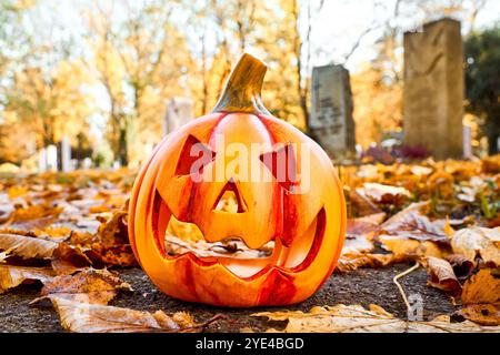 Baviera, Germania - 29 ottobre 2024: Una zucca di Halloween in un cimitero. Immagine simbolica di tutte le sere dei doni del 31 ottobre *** Ein Halloween-Kürbis auf einem Friedhof. Symbolbild All Hallows sera, 31 ottobre Foto Stock