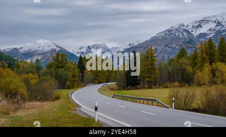 L'autunno getta un bagliore dorato su Falensee, con strade tortuose che conducono attraverso lussureggianti foreste e maestose montagne. Foto Stock