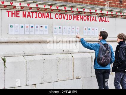 Cuori dipinti di rosso sul muro del National Covid Memorial sulla riva sud del Tamigi, di fronte alla Houses of Parliament, Londra, Inghilterra. Foto Stock