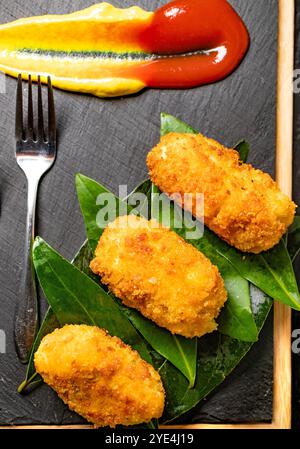 Una vista di un piatto di crocchette di antipasti servito in uno stile gourmet. Crocchette spagnole tradizionali fatte in casa. Foto Stock