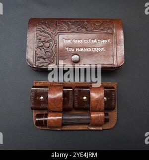 Un kit di rasoio da viaggio vintage di fabbricazione inglese, composto da un rasoio Wardonia in bachelite contenuto in una custodia in pelle aderente. Prodotto da Herbert O. Worrall and Co. Come parte della gamma «Arden Forest Leather Goods». La custodia in pelle marrone è decorata con un attraente design in foglia di quercia goffrata e ghianda ed è contrassegnata con la frase "per una rasatura pulita che desideri sempre". Foto Stock