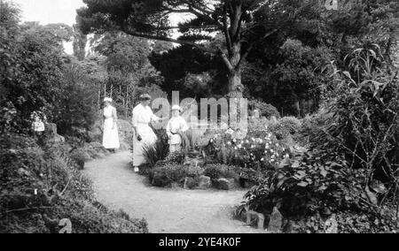 West Sussex, Inghilterra. c.1913 - Una donna e due bambini piccoli, che si ritiene siano parenti della famiglia Henty, accompagnati dalla loro tata, si trovano nei giardini all'interno dei terreni di Ferring Grange. Questa tenuta era la casa di Edwin Henty, J. P, D.L., F.S.A. (1844 – 1916), che era stato alto sceriffo del Sussex. Nel 1924, la casa fu convertita in un hotel alla moda, visitato da molte celebrità tra cui Edoardo, il Principe di Galles (in seguito noto come Duca di Windsor). La casa fu distrutta da un incendio nell'ottobre 1946. Foto Stock