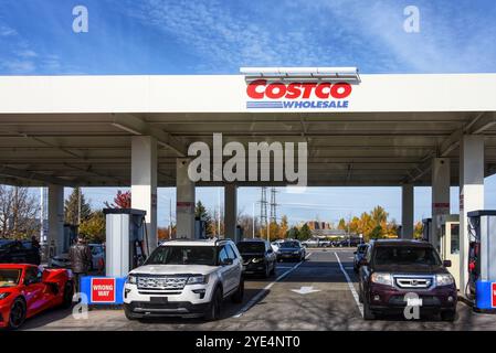 25 ottobre 2024: Una linea di auto che si riempie presso il distributore di benzina Costco Wholesale, che offre sconti sulla benzina a persone con abbonamenti a pagamento. Severa Foto Stock