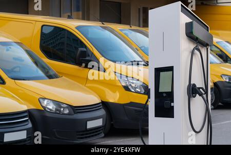 Furgoni elettrici con stazione di ricarica per veicoli elettrici. Foto Stock