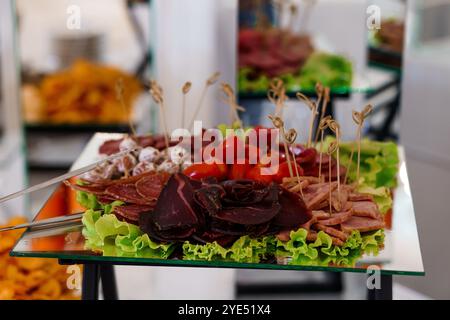 Squisita tavola di salumi con carni assortite e pomodori freschi. Foto Stock