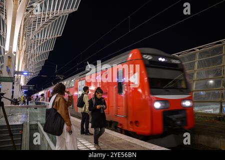 I passeggeri sono visti camminare su una delle piattaforme verso un treno alla stazione ferroviaria Oriente di Lisbona. I conducenti e i lavoratori della Comboios de Portugal (compagnia ferroviaria portoghese) hanno iniziato uno sciopero che durerà fino al 3 novembre, a causa di una crescente carenza di prestazioni e stipendi. L'azienda prevede interruzioni dei servizi, soprattutto il 31 ottobre. Foto Stock