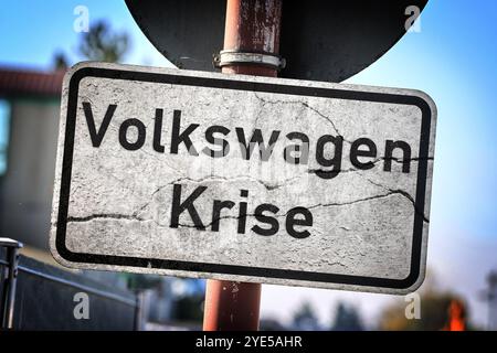 29 ottobre 2024: Immagine simbolica della crisi VW e delle conseguenti chiusure di impianti e sfide economiche. Segnale stradale incrinato con iscrizione: Crisi Volkswagen. FOTOMONTAGGIO *** Symbolbild zur VW-Krise und den damit verbundenen Werksschließungen und wirtschaftlichen Herausforderungen. Rissiges Verkehrsschild mit Aufschrift: Volkswagen-Krise. FOTOMONTAGE Foto Stock