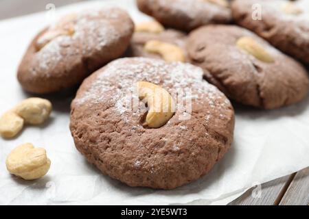 Deliziosi biscotti al cioccolato con anacardi e zucchero a velo sul tavolo, primo piano Foto Stock