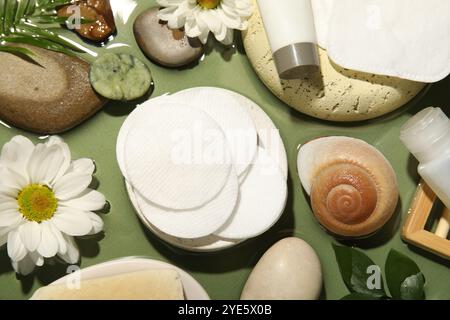 Composizione piatta con tamponi e tamponi di cotone su un tavolo verde Foto Stock