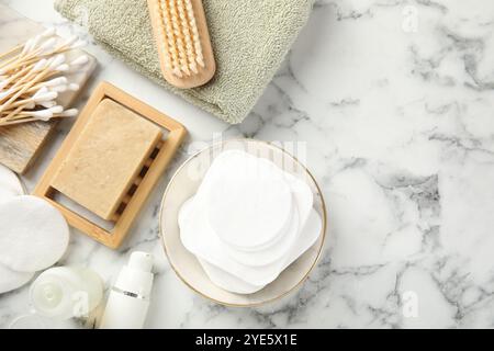 Composizione piatta con tamponi di cotone su tavolo in marmo chiaro, spazio per testo Foto Stock