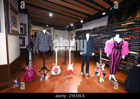 (L-R) Guns N' Roses Gilby Clarke suonò sul palco Gibson Les Paul (viola) chitarra elettrica e camicia, Van Halen chitarra elettrica autografata (grafica della bandiera canadese), Eric Clapton suonò e firmò la chitarra Fender Stratocaster, il costume blu Giorgio Armani indossato da George Michael per il tour dal vivo '25', gli Oasis firmarono Epiphone Noel Gallagher chitarra Super Nova (finale Union Jack) e Katy Perry indossarono la tuta New York durante l'esibizione hard Rock, durante il concerto di Julien '2019 NY, 28 ottobre 2024. (Foto di Anthony Behar/Sipa USA) Foto Stock