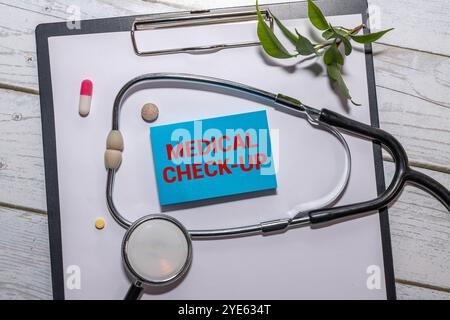 Concetto medico. Sugli elettrocardiogrammi c'è uno stetoscopio e un adesivo con l'iscrizione - CONTROLLO MEDICO SU Foto Stock