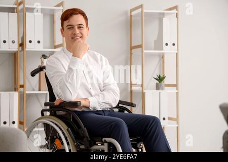 Giovane uomo d'affari in sedia a rotelle in ufficio Foto Stock
