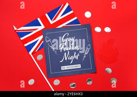 Biglietto d'auguri per la notte di Guy Fawkes, bandiera della Gran Bretagna, coriandoli e decorazioni in carta su sfondo rosso Foto Stock