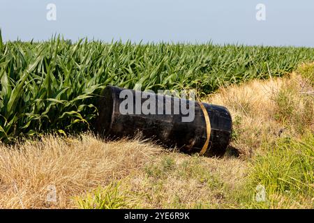 Serbatoio carburante scaricato nel fosso lungo la strada. Concetto di scarico al volo, inquinamento ambientale e smaltimento di rifiuti pericolosi Foto Stock