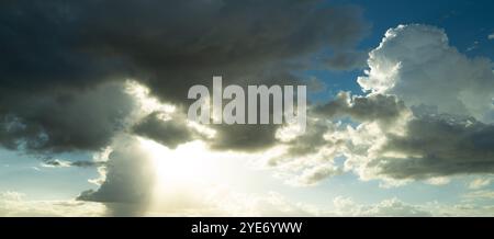 Un bellissimo cielo al tramonto con nuvole. Luce azzurra e arancione del sole attraverso le nuvole del cielo. Sfondo di nuvole scure prima della tempesta. Drammatico Foto Stock