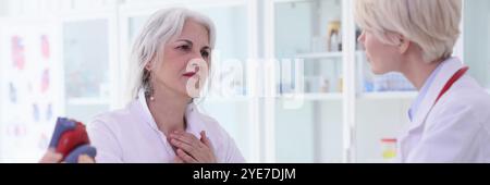 Donna paziente mette le mani sul torace lamentandosi di dolore Foto Stock