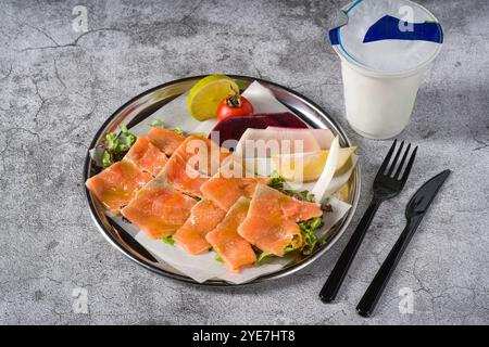 Salmone affumicato con verdure sotto di esso su un tavolo di pietra Foto Stock