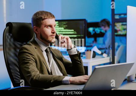 Specialista della sicurezza informatica che parla al telefono Foto Stock