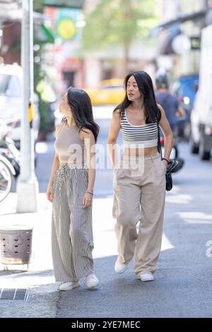 Due donne taiwanesi dei 30 anni che indossano abiti casual camminano lungo Dihua Street a Taipei, Taiwan, a settembre. Foto Stock