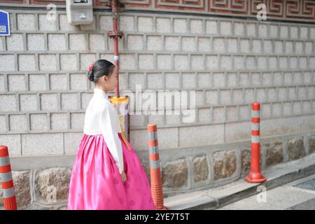 Una bambina coreana di 9 anni che indossa un hanbok cammina per le strade storiche di Gyedong-gil, Jongno District, Seoul, Corea. Foto Stock