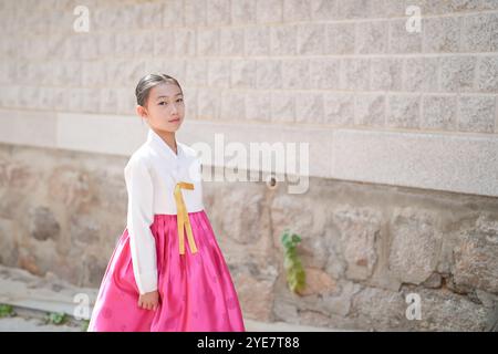 Una bambina coreana di 9 anni che indossa un hanbok cammina per le strade storiche di Gyedong-gil, Jongno District, Seoul, Corea. Foto Stock