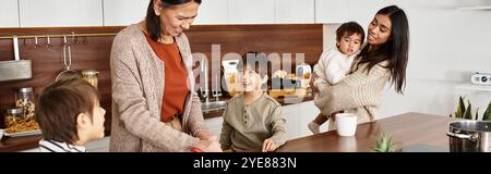 Una felice famiglia asiatica che cucina in una cucina moderna mentre si prepara per il Natale insieme. Foto Stock