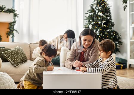 Una gioiosa famiglia asiatica ama trascorrere del tempo insieme decorando vicino al loro albero di Natale, festeggiando le vacanze invernali. Foto Stock