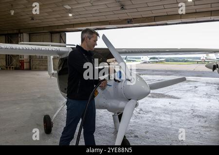 Ex pilota RAF Adam Twidell con il Pipistrel Velis Electro il primo aereo elettrico completamente certificato della Gran Bretagna, Fairoaks Airport, Surrey, Inghilterra Foto Stock