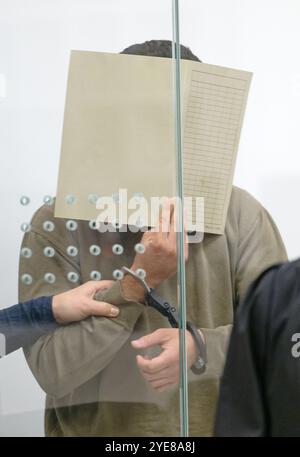 Duesseldorf, Germania. 30 ottobre 2024. L'imputato si trova in un'aula di tribunale presso il Tribunale regionale superiore di Düsseldorf all'inizio del processo. Un ventunenne è sospettato di aver preparato un attacco terroristico islamico con un'autobomba in Europa. Dal 30 ottobre 2024, l'uomo sarà processato come imputato dinanzi al Tribunale regionale superiore di Düsseldorf. Il pubblico ministero accusa anche il siriano di essere membro del gruppo terroristico dello Stato islamico. Credito: Henning Kaiser/dpa/Alamy Live News Foto Stock