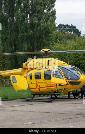 L'ambulanza gialla East Anglian Air dopo aver risposto a un'emergenza nel Suffolk rurale di Framlingham attende con l'equipaggio in un parcheggio Foto Stock