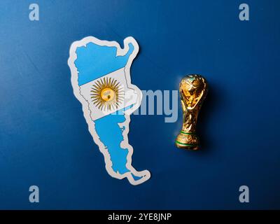 Primi piani adesivi con bandiera argentina con trofeo di coppa del mondo su sfondo blu. Foto Stock